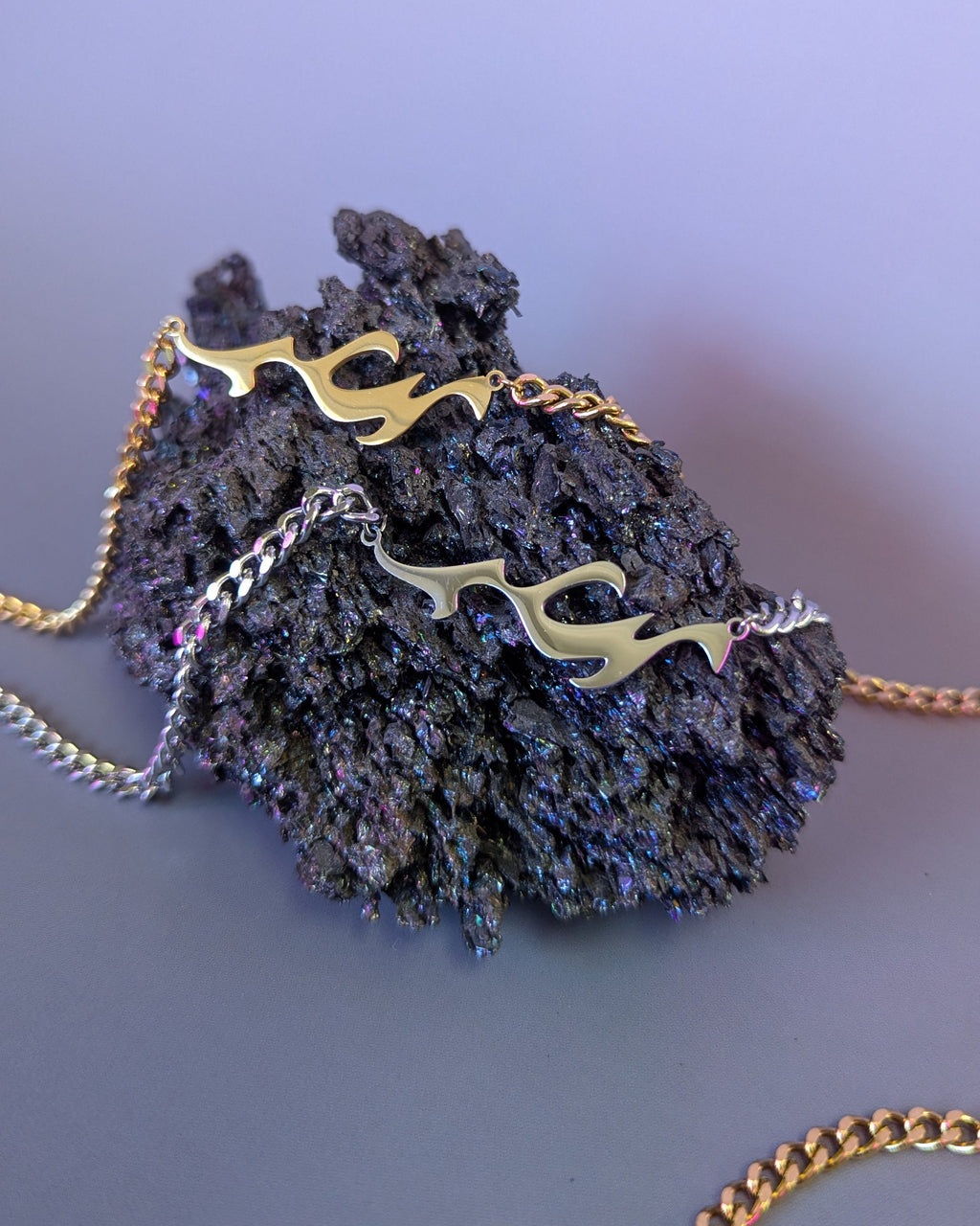 Necklace with gold chain and decorative elements on a purple background