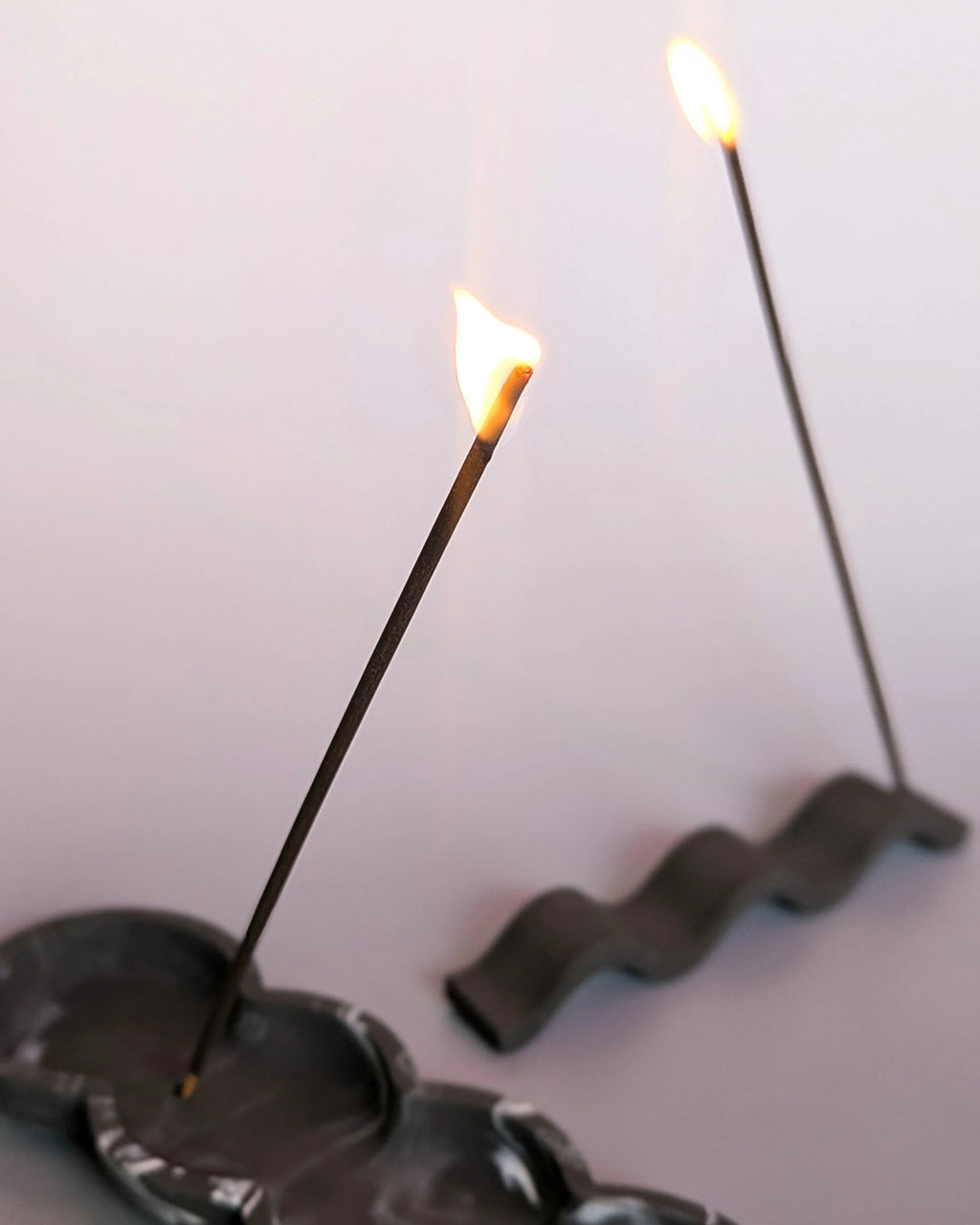 Incense sticks with a wavy incense holder on a light background